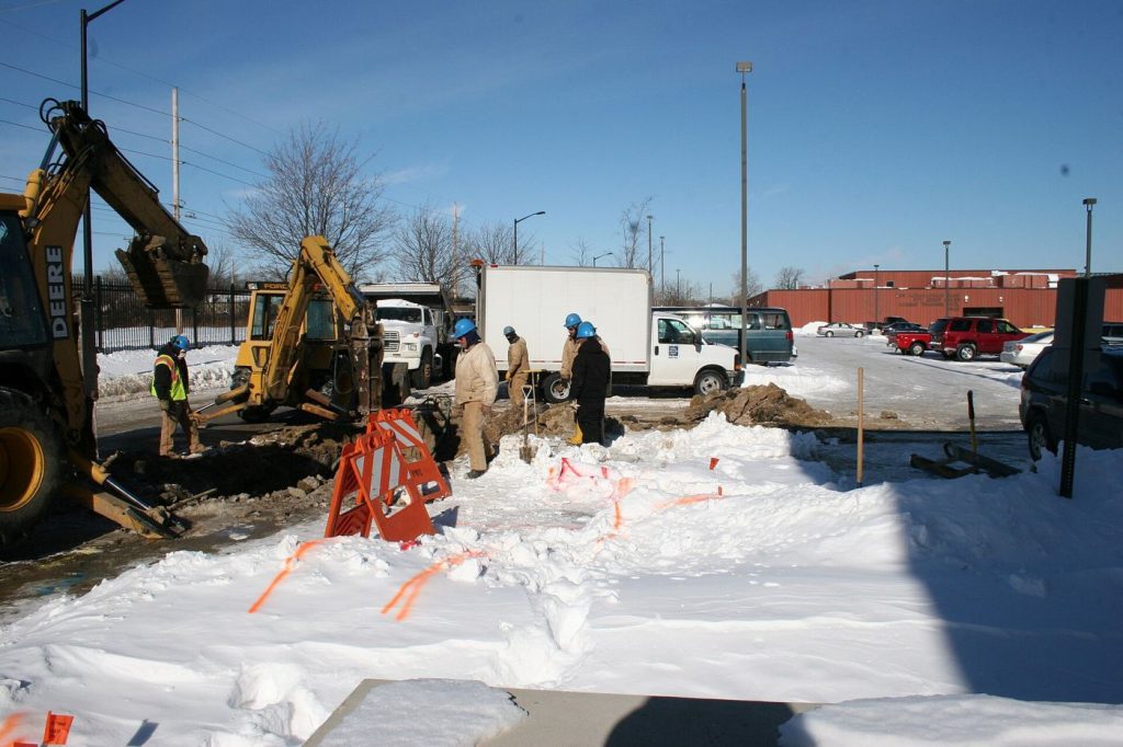 Leak Detection Teams Target Districts With the Oldest Mains workers repairing underground water pipes